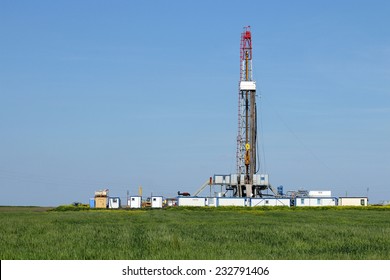 land oil drilling rig on green field