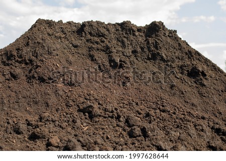 Land for planting plants. The ground is a pile. Land for flowerbeds. The black earth lies in a scattering.