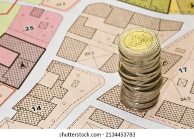 Land registry fees in European Union - concept with an imaginary cadastral map of territory with buildings, land parcel european euro coins - Shutterstock ID 2134453783