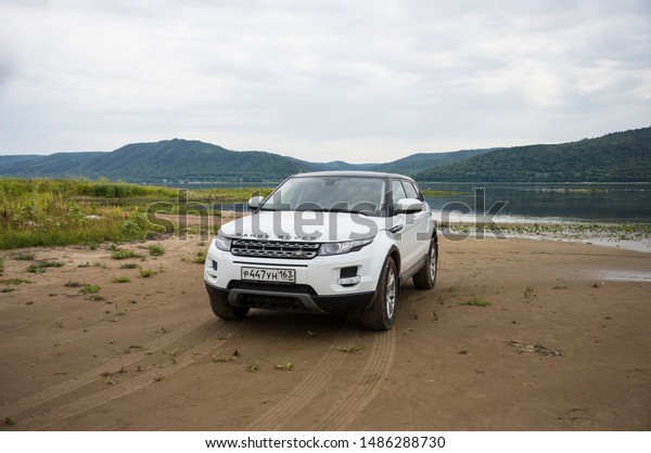 Land Rover Range Rover is\
located on the background of the Volga river and Zhiguli mountains\
on a cloudy summer day near the city of Samara, Russia. 8 Aug\
2019