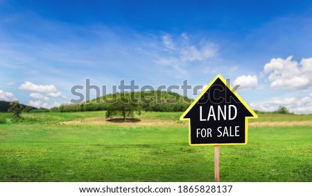land for sale sign against trimmed lawn background. Empty dry cracked swamp reclamation soil, land plot for housing construction project in rural area and beautiful blue sky with fresh air.