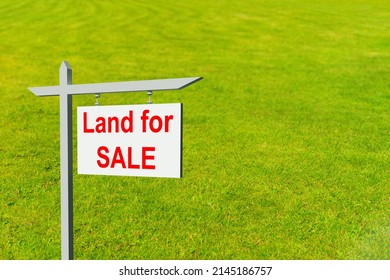 Land For Sale Sign. Illustration On Theme Of Real Estate. Purchase Of A Land Plot. White Sign For Sale On A Lawn Background. Concept - Plot Of Land For Sale By A Realtor. Realtor Business.