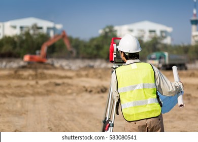 Land Survey And Asian Civil Engineer Working With His Equipment.