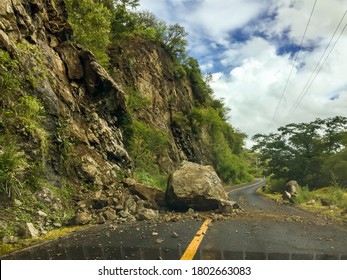 Landfall on a mountain road. Huge boulders lie on the roadway.