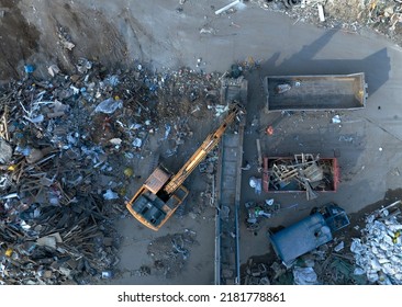 Landfill with Construction waste (CDW). Trash disposal for recycling and re-use. Excavator log grab crane on landfill. Recycling of Construction waste or debris. Secondary raw. Wood Waste Recycling.
