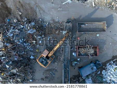 Landfill with Construction waste (CDW). Trash disposal for recycling and re-use. Excavator log grab crane on landfill. Recycling of Construction waste or debris. Secondary raw. Wood Waste Recycling.

