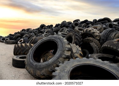 Landfill with old tires and tyres for recycling. Reuse of the waste rubber tyres. Disposal of waste tires. Worn out wheels for recycling. Tyre dump burning plant. Regenerated tire rubber produced. 
