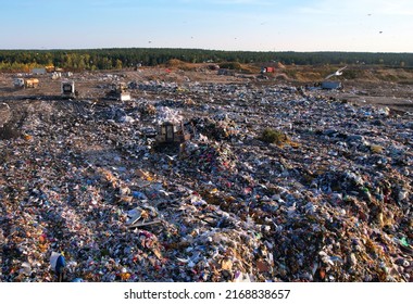 Landfill waste area. Bulldozer at landfill working on rubbish disposal. Garbage dump with waste plastic, polyethylene and food waste. Trash disposal for recycling and re-use. Soft focus. - Shutterstock ID 2168838657