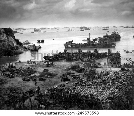 Landing craft of supply U.S. forces on Okinawa, 13 days after the initial invasion. Beyond are U.S. battlewagons, cruisers and destroyers. April 13, 1945.