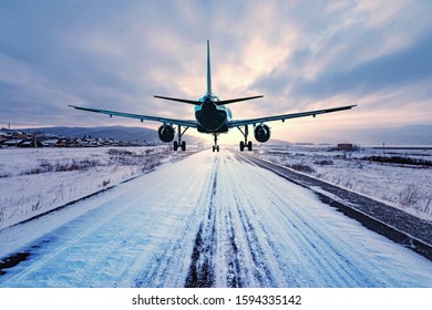 Landing Of The Passenger Plane To The Highway At Winter Evening Time.