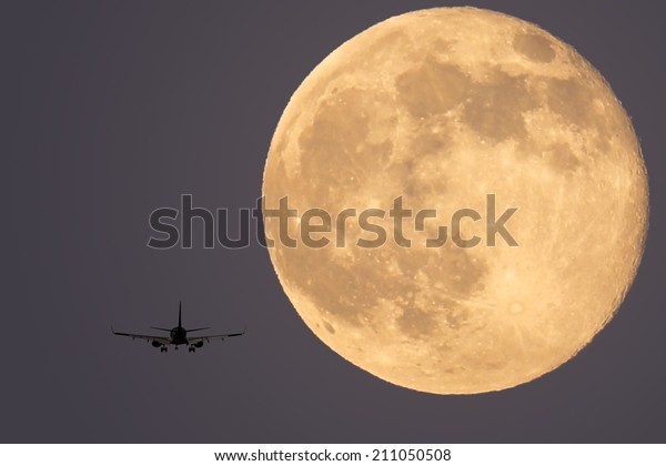 Landing plane on a full\
moon background