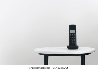 Landline Phone On Nightstand In Modern Room With White Wall. Home Comfort And Gadgets. VOIP Technology. Telecommunication Concept. Means Of Connection