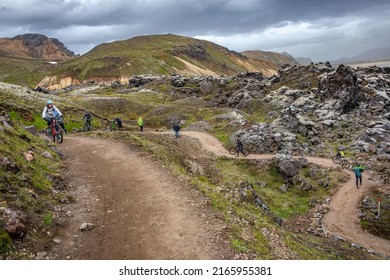 Landmannalaugar, Iceland - July 10, 2018: colorful rainbow volcanic mountains Laugavegur hiking trail with dramatic sky, colorful rhyolite volcano, lava fields and cyclists with mountain bikes