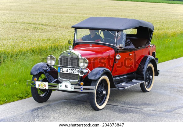 LANDSBERG, GERMANY - JULY 12, 2014: Public oldtimer\
rally organized by Bavarian city Landsberg for at least 80 years\
old veteran cars with unknown drivers in Ford A Phaeton de Luxe,\
built at year 1928