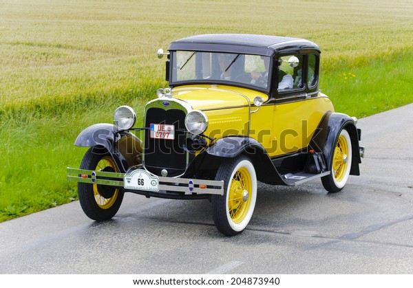 LANDSBERG, GERMANY - JULY 12, 2014: Public oldtimer\
rally organized by Bavarian city Landsberg for at least 80 years\
old veteran cars with unknown drivers in Ford A Coupe, built at\
year 1930