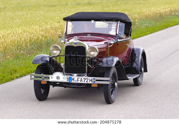 LANDSBERG, GERMANY - JULY 12, 2014: Public oldtimer\
rally organized by Bavarian city Landsberg for at least 80 years\
old veteran cars with unknown drivers in Ford A Roadster, built at\
year 1930