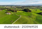 Landscape in the Allgaeu in autumn with meadows, forests, mountains and individual farms. Trees with red and yellow autumn leaves. West Allgaeu, Bavaria, Germany