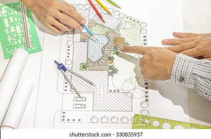Landscape architect changing drawing at meeting with client