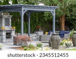 Landscape architecture featuring pergola and stone fireplace with stone urn water fountains