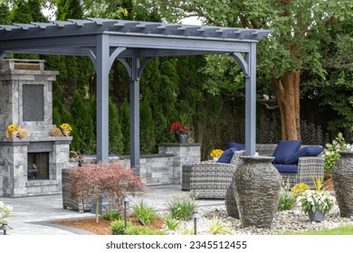 Landscape architecture featuring pergola and stone fireplace with stone urn water fountains