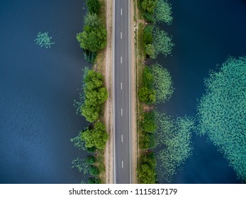 Landscape Of An Asphalt Road. View From Above On The Road Going Along The Blue River. Summer Photography With Bird's Eye View.