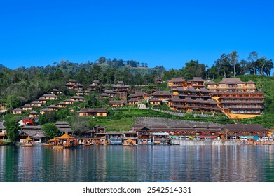 landscape of "Ban Rak Thai Village in Mae Hong Son province at dusk, showcasing a serene lakeside scene with floating lanterns and glowing reflections, surrounded by traditional buildings - Powered by Shutterstock