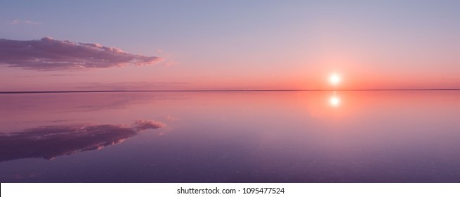 Landscape beautiful golden sunset red sky solt lake saline Elton Baskunchak. The sun sets behind the horizon