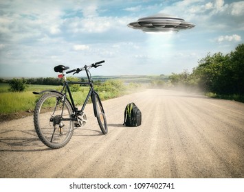 Landscape with bike on the road and UFO. Fiction scene with alien spaceship. Photo with 3d rendering element and vintage film camera effects