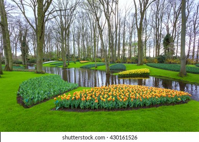 Landscape with blooming beautiful flowers and water stream in famous Keukenhof park in Netherlands. Spring garden. Nature background