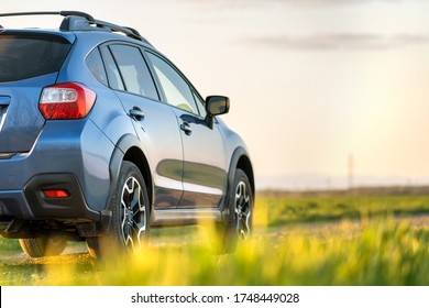Landscape with blue off road car on gravel road. Traveling by auto, adventure in wildlife, expedition or extreme travel on a SUV automobile. Offroad 4x4 vehicle in field at sunrise.
