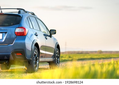 Landscape with blue off road car on gravel road. Traveling by auto, adventure in wildlife, expedition or extreme travel on a SUV automobile. Offroad 4x4 vehicle in field at sunrise. - Shutterstock ID 1928698124