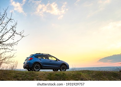 Landscape with blue off road car at sunset, Traveling by auto, adventure in wildlife, expedition or extreme travel on a SUV automobile. Offroad 4x4 vehicle in field at sunrise.