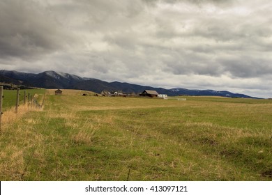 Landscape With Cabin On A Montana Ranch. Mountains In Background.