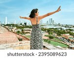 Landscape of Cartagena de Indias with native woman raised arms, Colombia