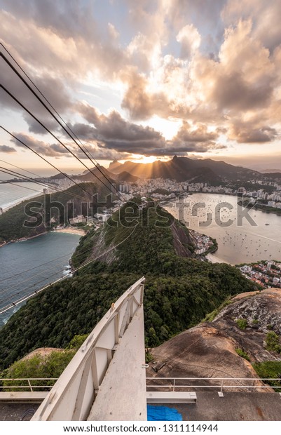 Landscape to the city with ocean,\
mountains and beautiful sunset clouds, seen from the top of Sugar\
Loaf Mountain (Pão de Açúcar), Rio de Janeiro,\
Brazil