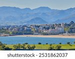 Landscape of the city of Santander, Spain, viewed from the observation deck of the Cabo Mayor lighthouse. Green vegetation in the foreground that highlights the green surroundings of the city.