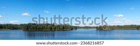 landscape with clouds and islands on a forest lake in summer
