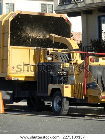 landscape crew using the wood chipper to cleanup tree trimmings