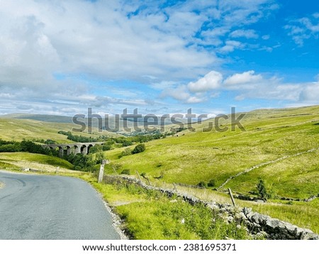 Landscape of Cumbria on a sunny summer day. Dent Head Viaduct, part of the Settle-Carlisle Railway, viewed from The Dales Way hiking route in northern England.
