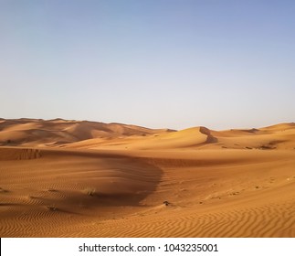 Landscape Of Desert In Dubai, Sand Dunes Which Lack Of Water And Vegetation In Hot Weather Under The Blue Sky In Daylight, And Rapid Temperature Change Between Day And Night When Darkness Revisited.