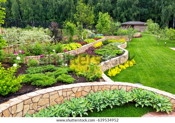 家庭花园中的自然景观美化全景 美丽的景色园景花园在后院 夏季景观美化区的风景 景观设计与花坛 库存照片 立即编辑