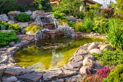 Landscape Design In Home Garden, Beautiful Landscaping With Small Pond And Waterfall. Landscaped Place With Stones And Water At Country House. Nice Pond And Fountain In Backyard Or Yard In Summer.