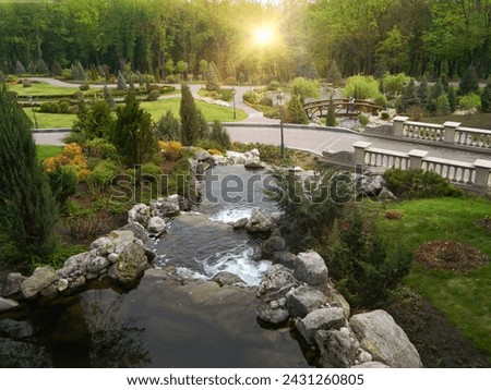 Landscape design in home garden, beautiful landscaping with pond and waterfall. Landscaped place with stones and water at country house. Nice pond and fountain in backyard or yard. High quality photo