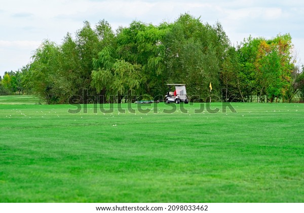 landscape. electric car on golf course and sky with\
clouds. lawn grass\
care.