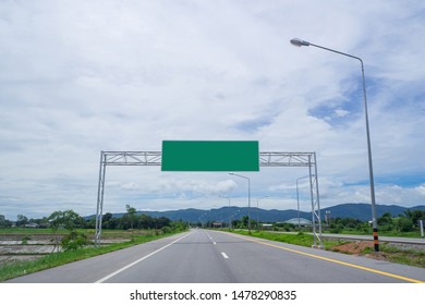 Landscape Of Empty Road Through Fields With Blank Highway Sign. Green Billboard For Text.