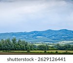 a landscape of fields, forests and hills