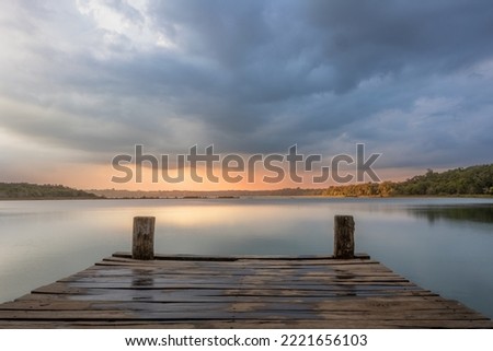 Landscape with freshwater lagoon and wooden deck and cloudy sky during golden hour in the tropical forest in Coba