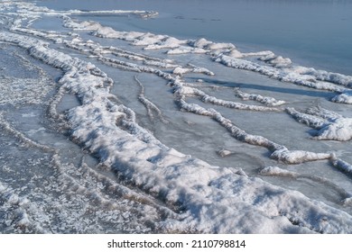 Landscape of a frozen lake, ice, water with blue sky on horizon. Winter cold climate