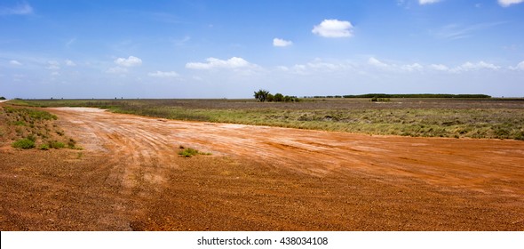 Landscape with gravel roads in the tropical summer Wet Season  at Roebuck Plains near Broome, North Western Australia, a region of natural grasslands  with fine alluvial and estuarine sediments  .