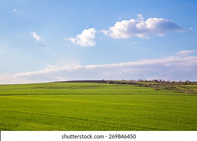 landscape with green field and blue sky with clouds